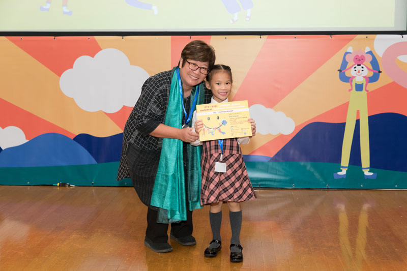 書伴我行（香港）基金會社區閱讀發展總監蔡淑玲女士頒發獎狀予幼兒組入圍者盧思妍小朋友。